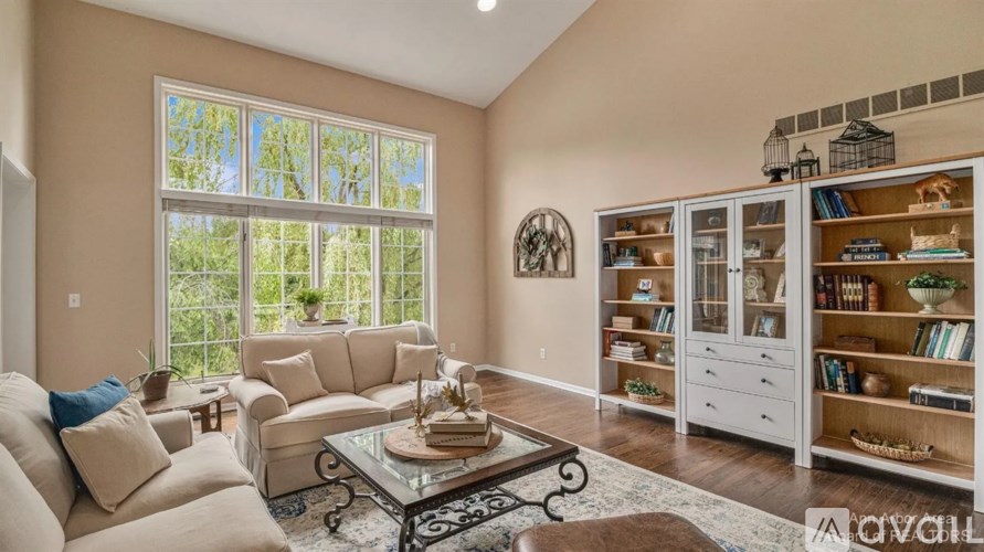 A living room with a glass table and a large window.