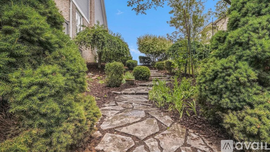A stone pathway leads through a lush garden.
