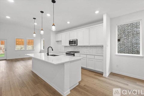 A modern kitchen with white cabinets and a central island.