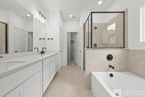 A modern bathroom with a white tub and a large mirror.