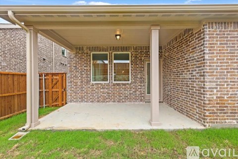 A covered patio area with a brick wall and a wooden door.