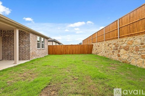 A backyard with a wooden fence and a stone wall.