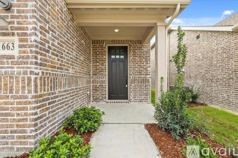 A black door is on the left side of a brick building.