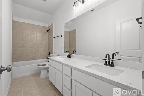 A bathroom with a white tub, toilet, and sink.