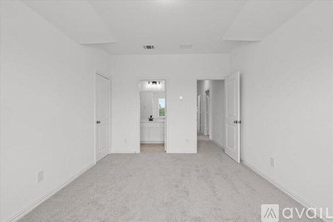 A spacious, empty room with white walls and carpeted floor.