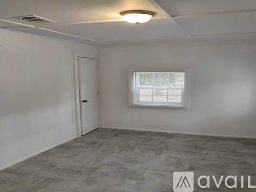 A room with a window and a door is available for rent.