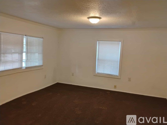 A room with a window and a wall-mounted light fixture.
