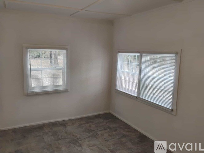 A room with two windows and a tiled floor.
