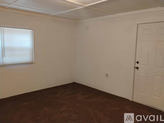 A room with a brown floor and a white door.
