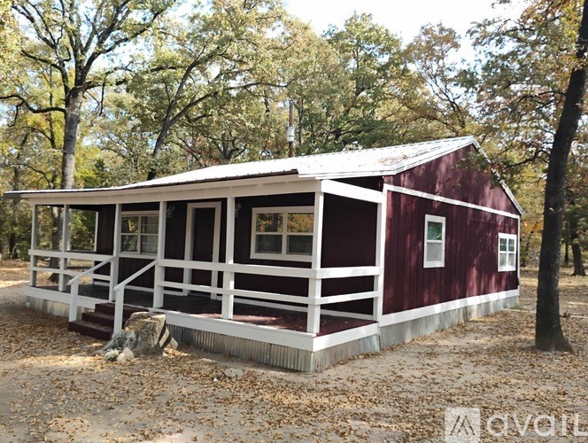 A red barn with white trim and a white fence.