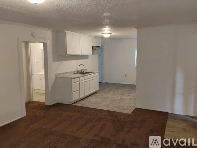 A kitchen area with white cabinets and a brown floor.