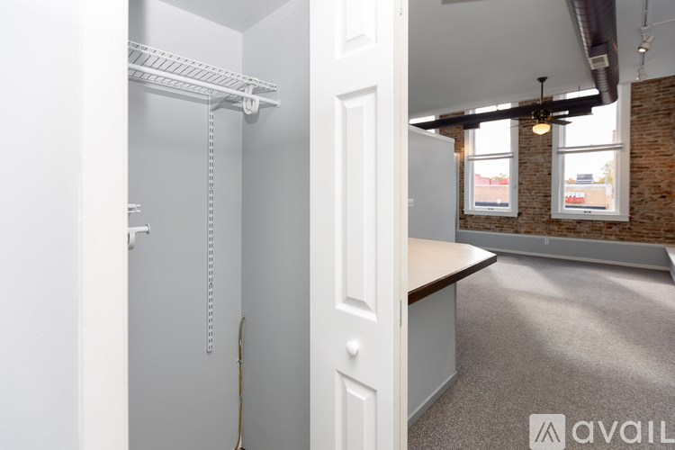 A white closet with a white door and a white shelf.