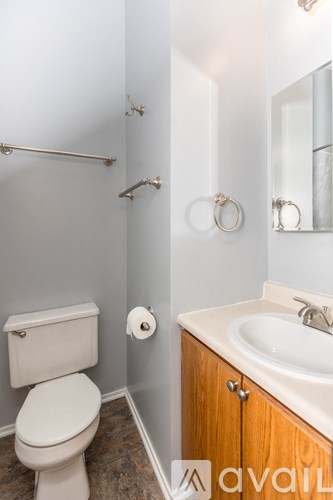 A bathroom with a toilet, sink, and towel rack.