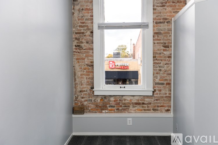 A window with a view of a building with a sign that says "Buffalo".