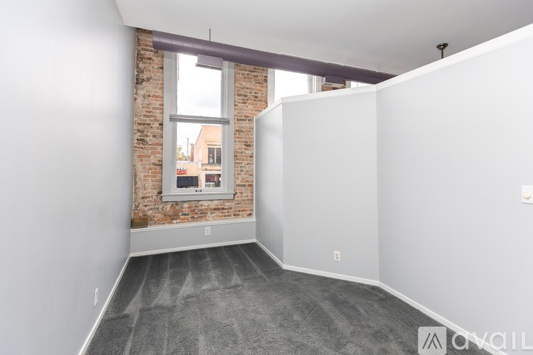 A room with a brick wall and a window.