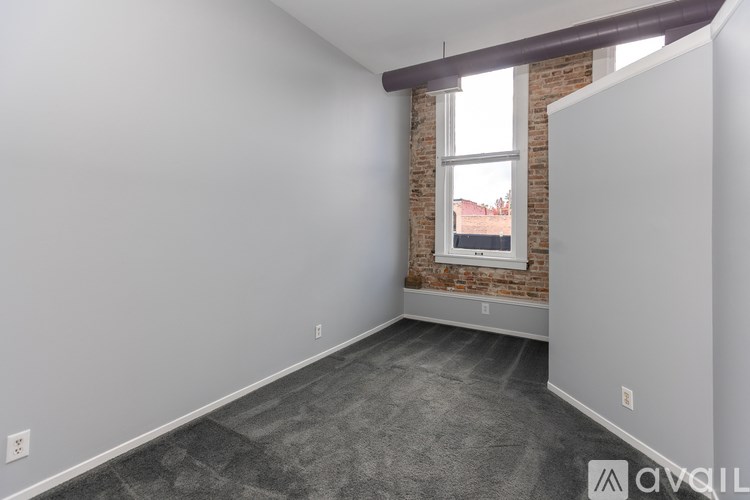 A room with a brick wall and a window.