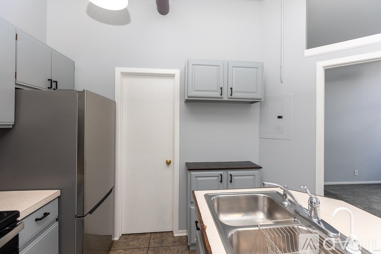A kitchen with a white door and a sink.
