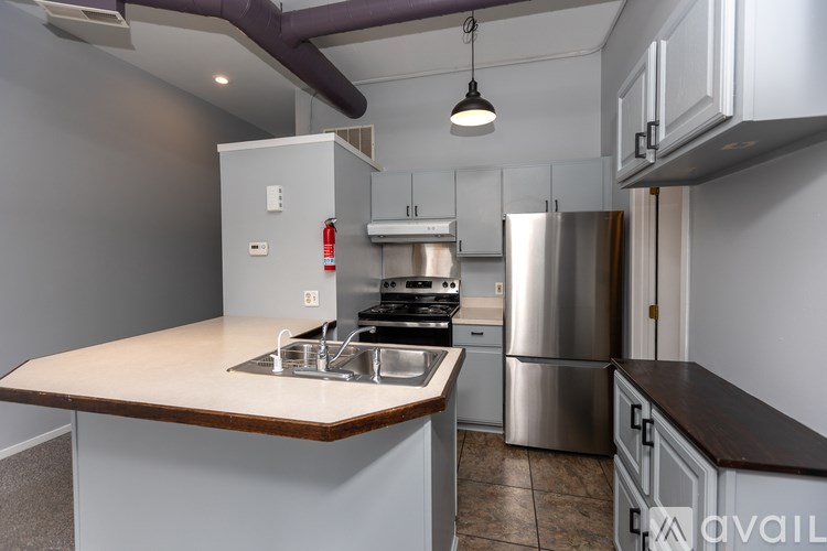 A kitchen with a stainless steel refrigerator and a wooden countertop.