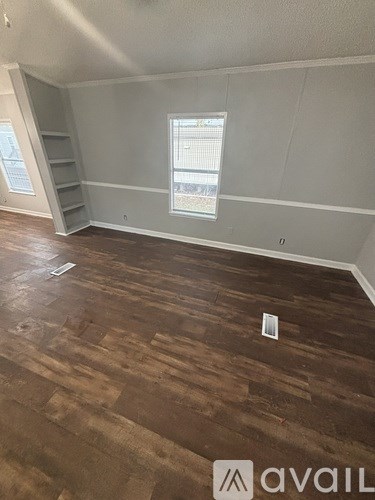 A room with wooden flooring and a window.