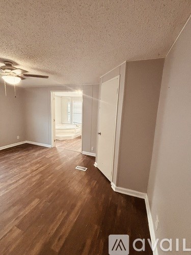 A room with wood flooring and a ceiling fan.