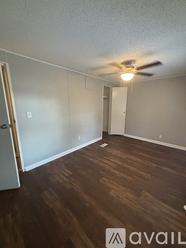 A room with wooden floors and a ceiling fan.