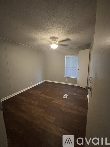 A room with a ceiling fan and a window.