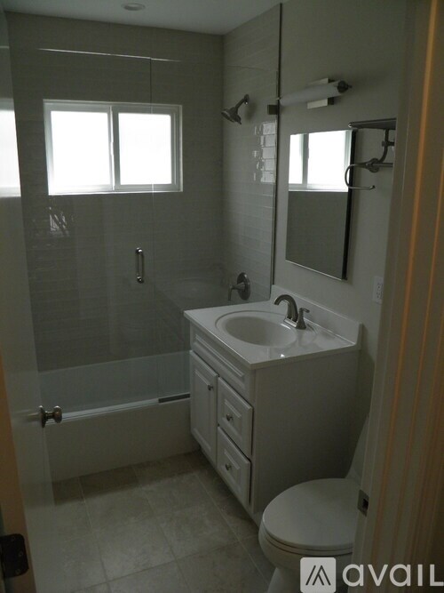 A bathroom with a toilet, sink, and shower.