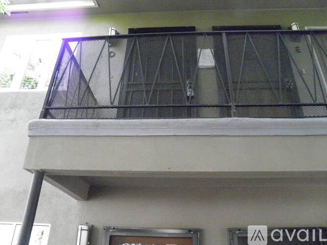 A balcony with a metal railing and a sign that says "AVAILABLE".