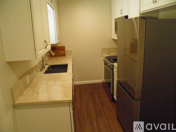 A kitchen with a refrigerator, stove, and countertop.