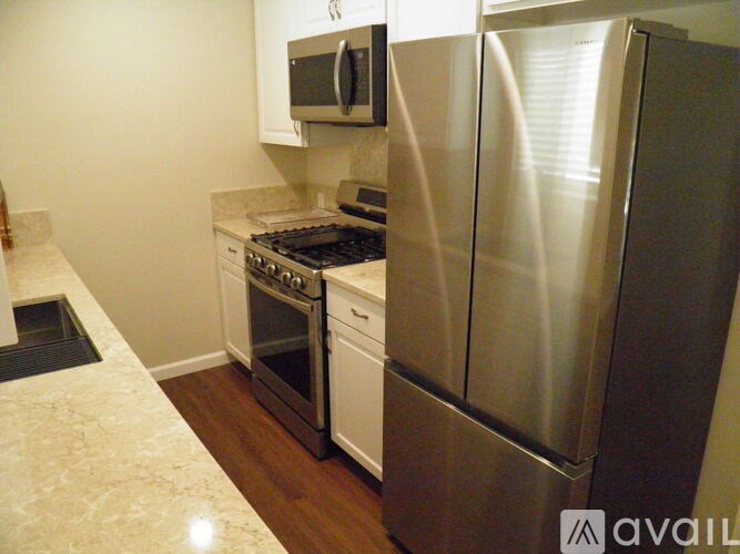 A kitchen with a stainless steel refrigerator and a stove top oven.