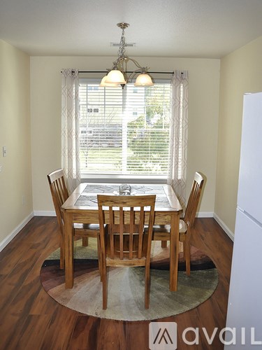 A dining room with a table and chairs.