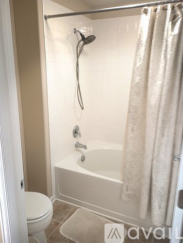 A bathroom with a white tub and toilet.