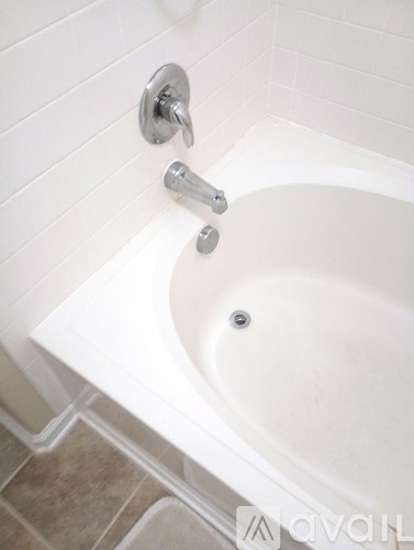 A white bathtub with a silver faucet and shower head.