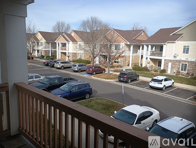 A view of a parking lot from a balcony with cars parked in it.