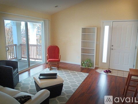 A living room with a red chair and a black couch.