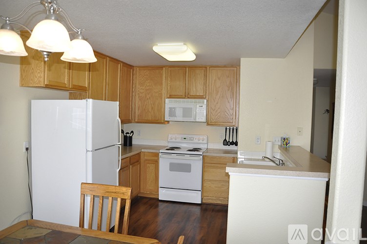 A kitchen with wooden cabinets and white appliances.