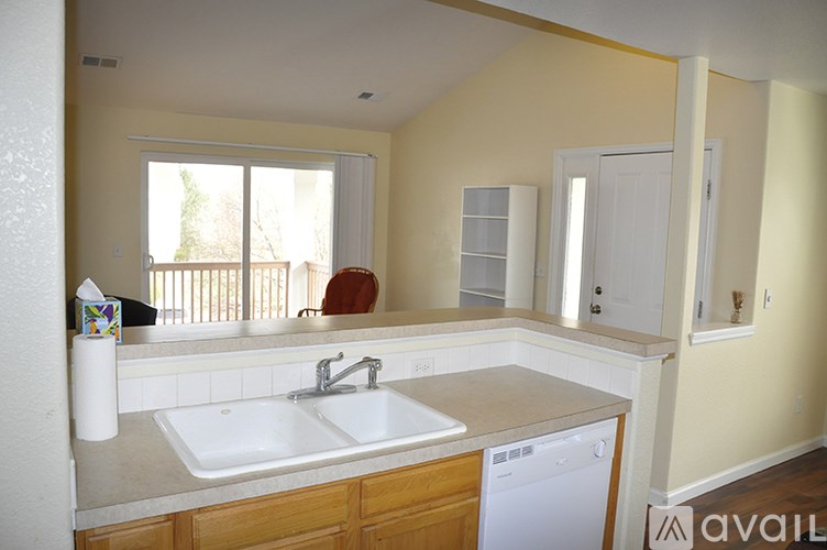 A kitchen with a white sink and a window.