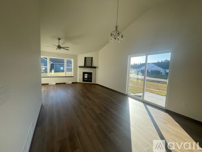 A spacious room with wood flooring and a ceiling fan.