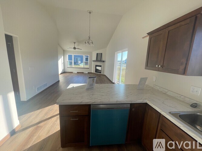 A kitchen with a countertop, cabinets, and a window.