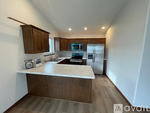 A kitchen with a countertop, cabinets, and a window.
