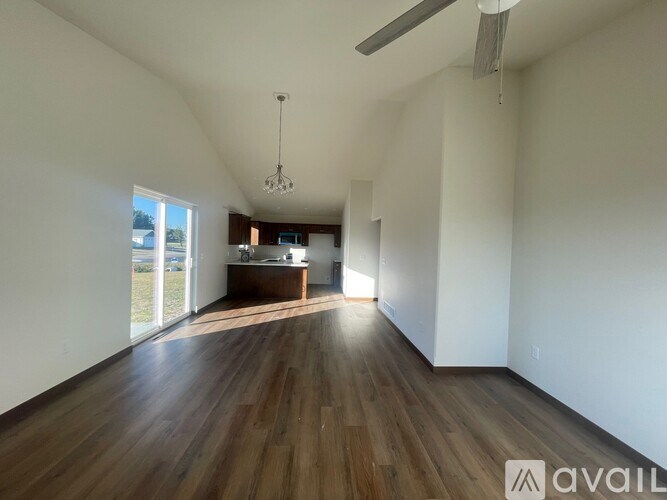 A spacious room with wooden floors and white walls.