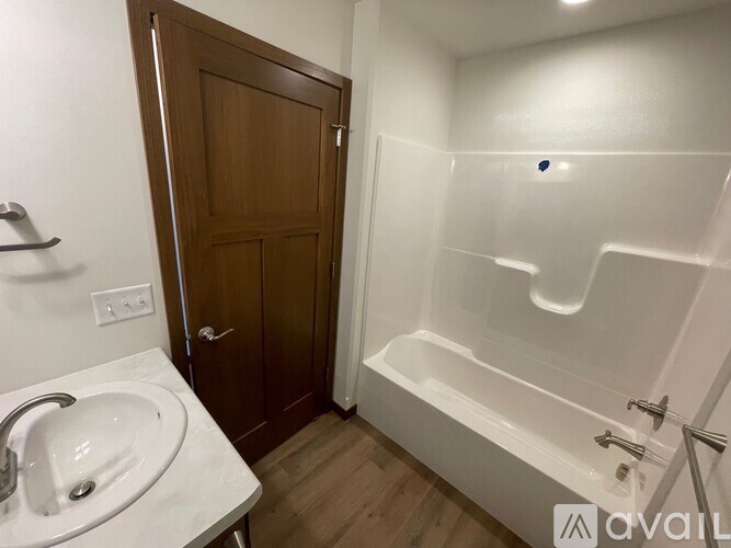 A bathroom with a white sink and a wooden door.