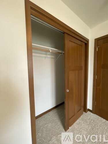 A room with a brown door and a white wall.