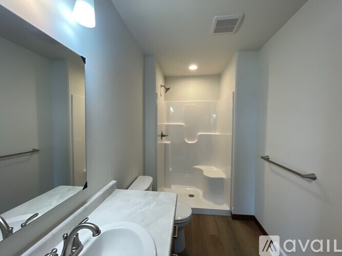 A bathroom with a toilet, sink, and mirror.