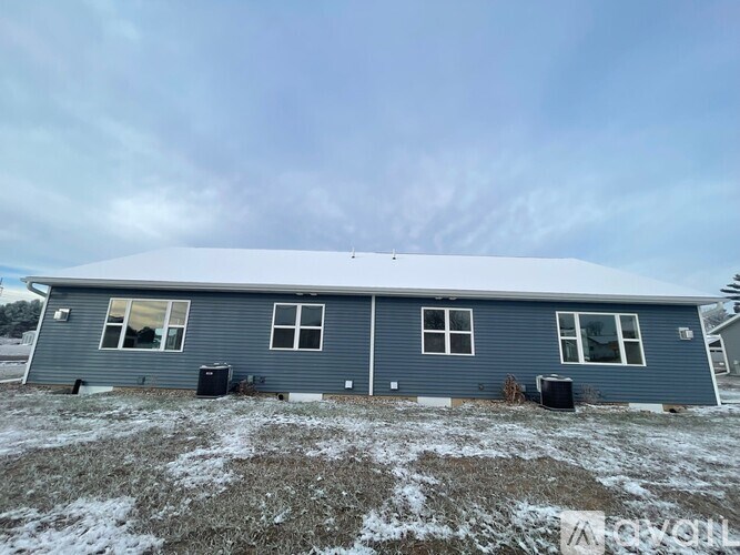 A long hallway with wooden floors and white walls.