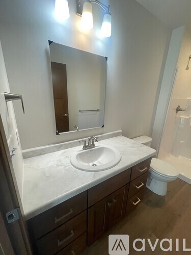 A bathroom with a sink, mirror, and toilet.