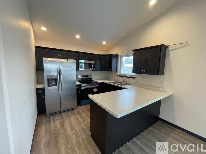 A spacious room with wooden floors and a ceiling fan.