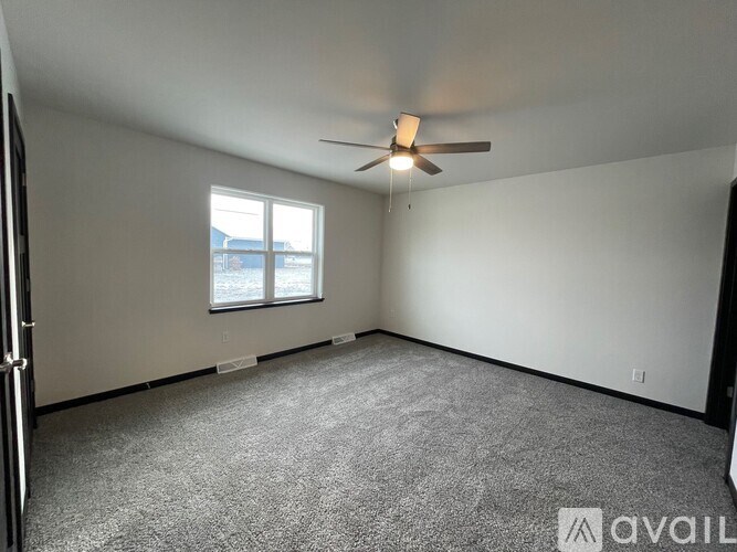 A room with a ceiling fan and a window.