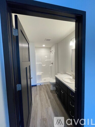A bathroom with a sink, toilet, and mirror.