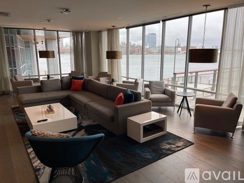 A living room with a view of the water and a city skyline.